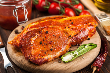Marinated pork steaks on cutting board