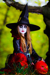 Cute girl dressed to Halloween costume in dark forest