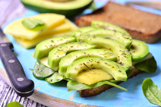 Sandwich with avocado,cheese and spinach leaves.
