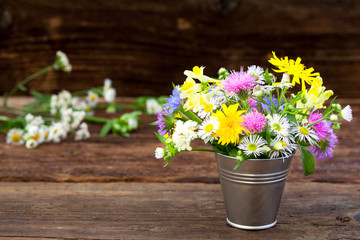 Bouquet of colorful meadow flowers on rustic table