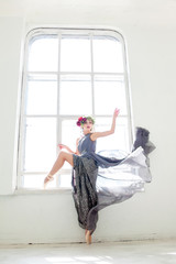 The beautiful ballerina posing in long gray dress 