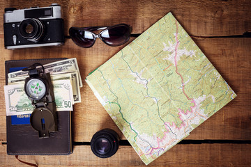 Fototapeta na wymiar travel equipment - map, backpack, vintage camera, sunglasses, compass, passport and money
