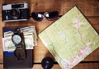 travel equipment -  map, backpack,  vintage camera, sunglasses, compass, passport and money