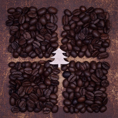 Wooden christmas tree on dark roasted coffee beans divided into