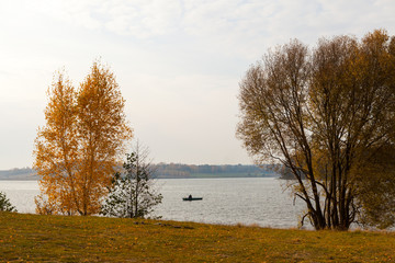 Autumn landscape with fisherman