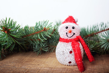 snowman, christmas tree and christmas lights on wooden background. New year and christmas decorations