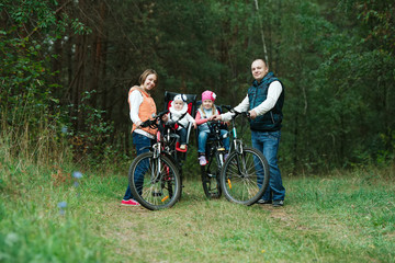 Naklejka premium happy family riding bike in wood