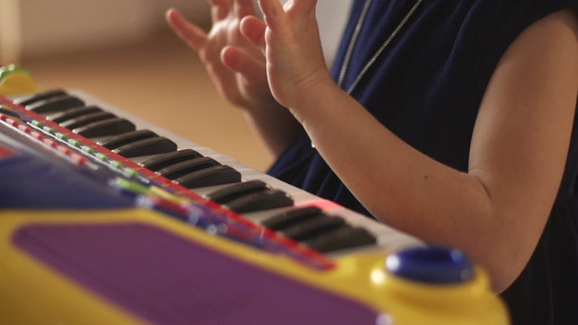 Hand of a child playing synthesizer
