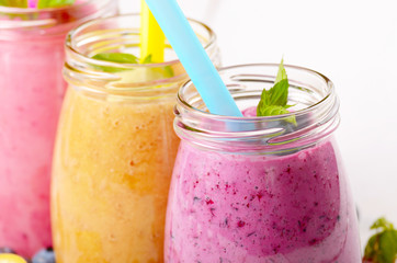 Assorted fruit shakes on white table