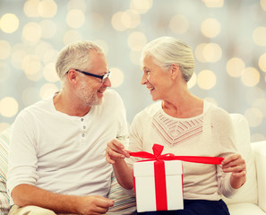 happy senior couple with gift box at home