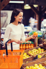happy young woman with food basket in market