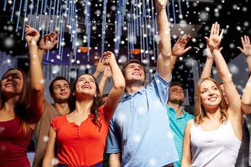 group of smiling friends at concert in club