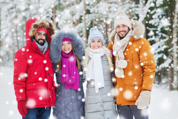 group of smiling men and women in winter forest