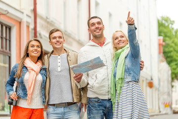 Fototapeta premium group of smiling friends with map and photocamera