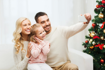 family taking selfie with smartphone at christmas