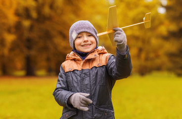 happy little boy playing with toy plane outdoors