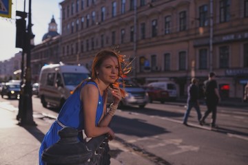 Fototapeta na wymiar Outdoor portrait of young beautiful caucasian woman walks on street in St.Petersburg, Russia