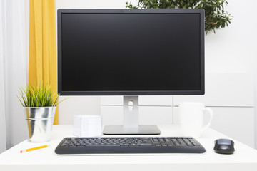 blank monitor on table in bright interior