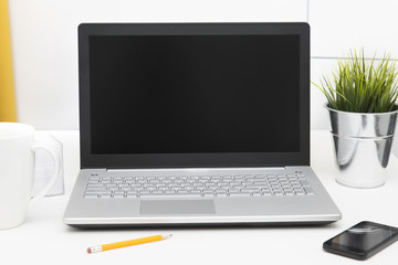 laptop with blank screen on white table