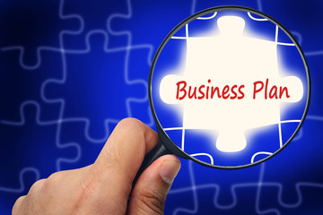 Business Plan word. Magnifier and puzzles.