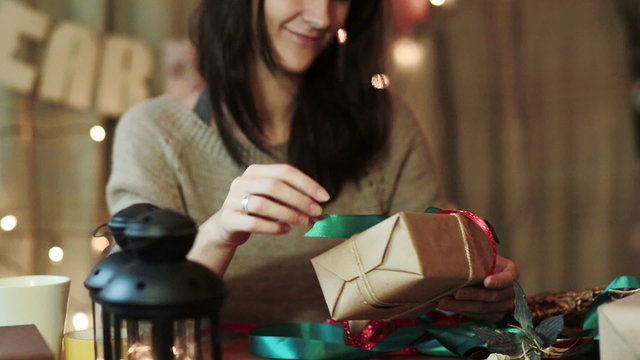 Young Woman Wrapping Christmas Gifts At Home