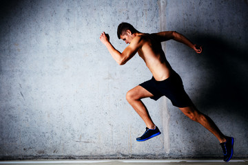 Runner sprinting against concrete wall in garage