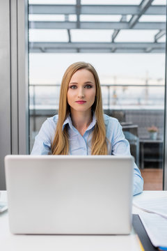 Confident young woman working on laptop