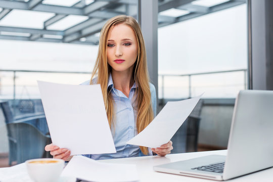 Young business woman comparing documents
