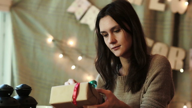 Young Woman Wrapping Christmas Gifts At Home