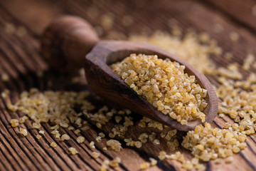 Raw Bulgur (on wooden background)