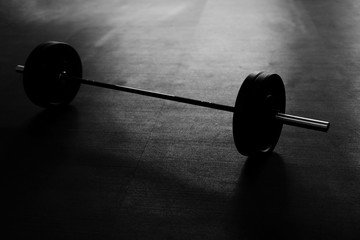Fototapeta na wymiar Black and white picture of barbells on the gym floor