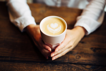 Closeup of woman holding warm cappuccino