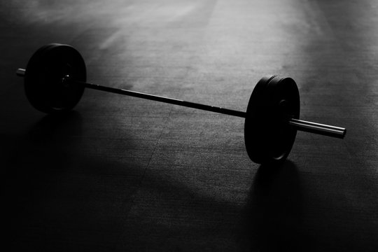 Black and white picture of barbells on the gym floor