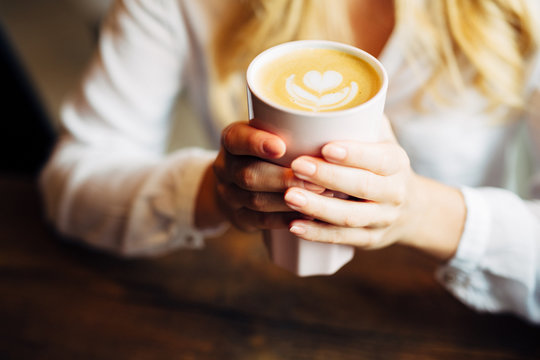 Closeup of woman holding warm latte