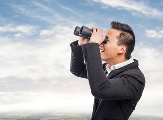 handsome young asian man looking trough a binoculars
