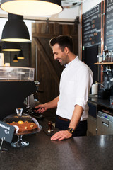 Happy barista grinding coffee