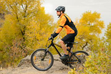 Cyclist Riding Bike on the Beautiful Autumn Mountain Trail