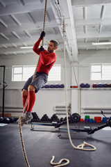 Fitness rope climb exercise at gym