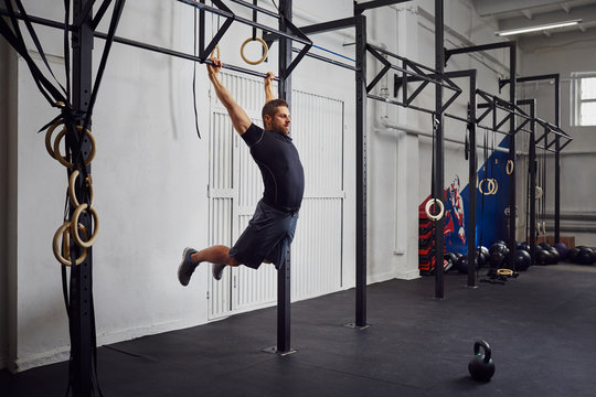 Man at gym exercise Kipping pull-ups