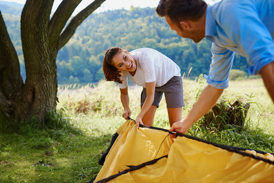 Happy couple setting up tent