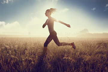 Young fit woman running during sunny morning