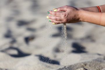 Close-up photo of the woman hands playing with sand