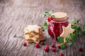Homemade cranberry sauce with fresh berries and cinnamon in a small glass jar