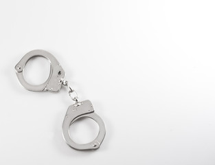 Photo of a pair of handcuffs isolated on a table
