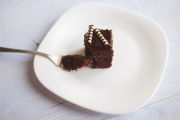 hand holding a fork with a piece of cake
