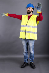 Young construction worker with hardhat directing traffic, showin