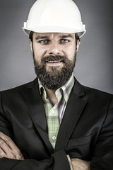 Closeup of young engineer with hardhat holding arms folded
