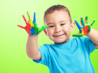 portrait of cute kid having fun with hands paint