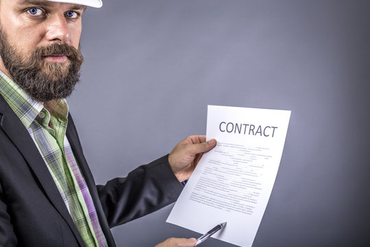Portrait of young engineer with hardhat holding a contract