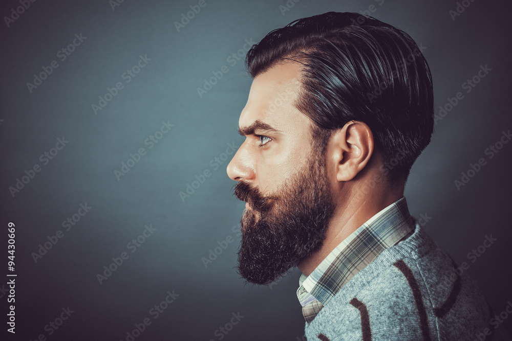 Wall mural Closeup of a handsome young man with retro look over gray background